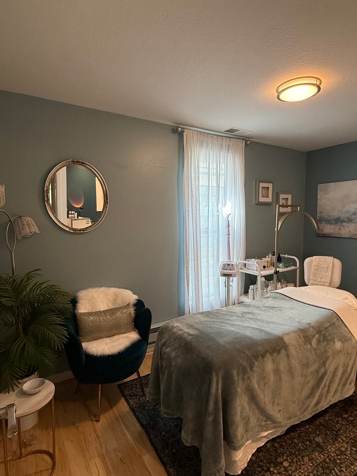 A treatment room, sage walls and the facial station